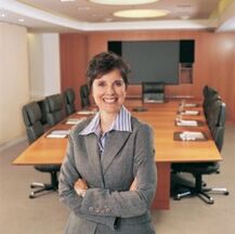 photo of a smiling executive standing in a Board room