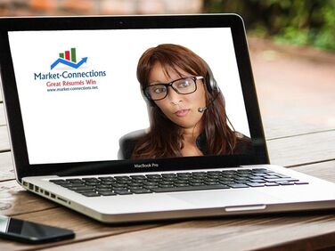 Photo of a lady on the monitor of a laptop wearing a headset. There is also a logo from https://www.market-connections.net