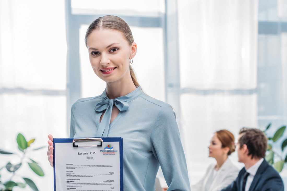 Selective focus of happy customer jobseeker holding clipboard with her resume. There is also a logo from https://www.market-connections.net