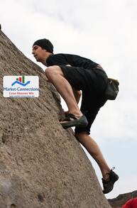 A man is climbing a mountain and ther is a logo of https://www.market-connections.net on the side